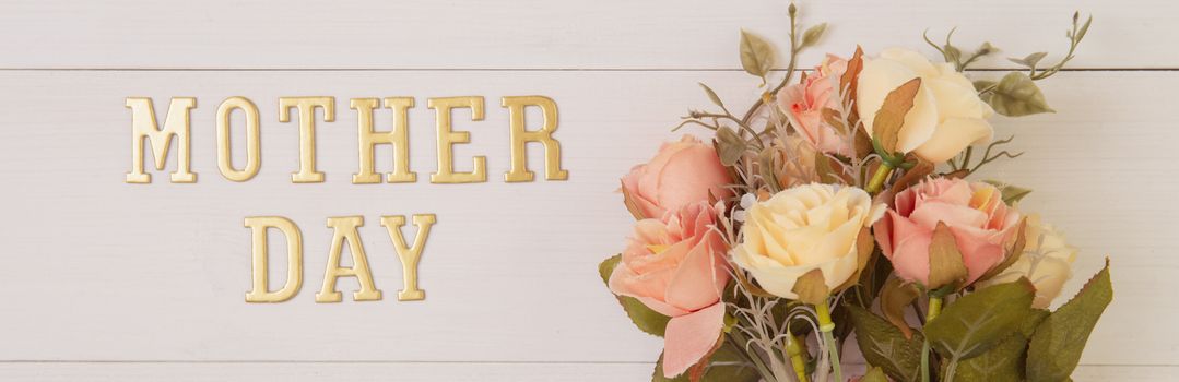 Beautiful flower and text mother day on wooden background with romantic, spring or summer nature for decoration, bouquet floral and word or message for gift on desk, holiday concept, banner website.