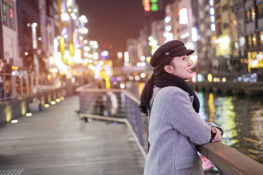 Beautiful smiling woman tourists traveling in walking at street shopping center Dotonbori in Osaka, Japan.