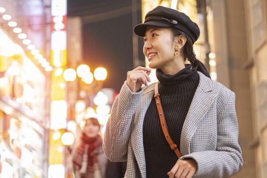 Beautiful smiling woman tourists traveling in walking at street shopping center Shibuya in Tokyo, Japan.