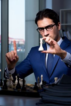 Businessman playing chess in strategy concept