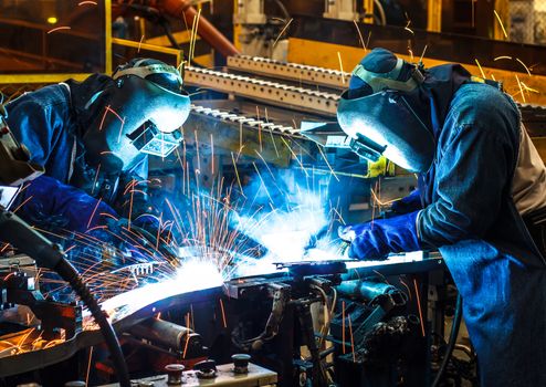 worker with protective mask welding metal