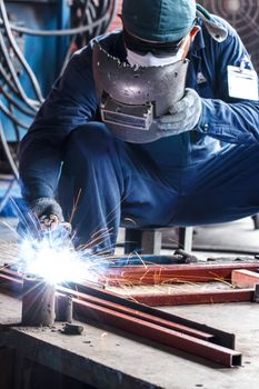 worker with protective mask welding metal