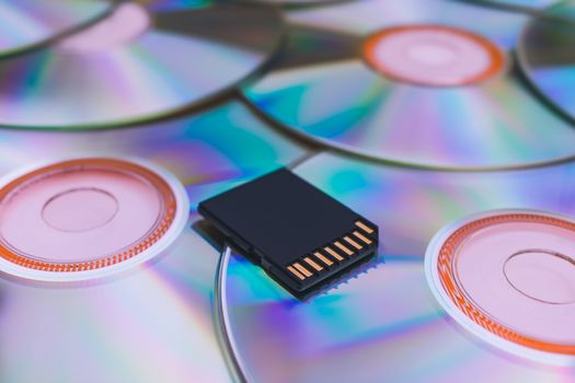 Modern storage of information on a flash drive compared to old disks. A modern flash drive lies on old CDs close-up