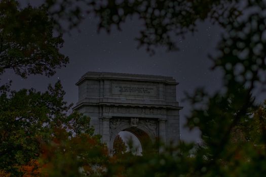 The National Memorial Arch at Valley Forge National Historical Park With Leaves Surrounding the Frame and a Night Sky Full of Stars in the Background