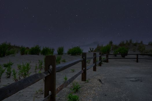 A Beach Path With a Fence on the Side and a Night Sky Full of Stars