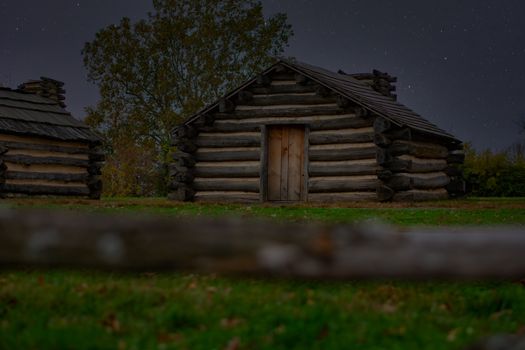 Reproduction Log Cabins at Valley Forge National Historical Park With a Night Sky Full of Stars Behind