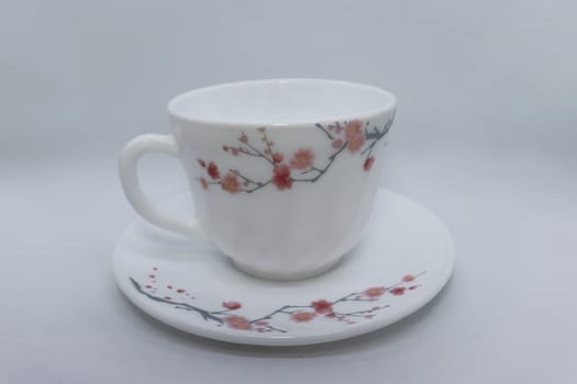 ceramic cup and plate closeup on white background