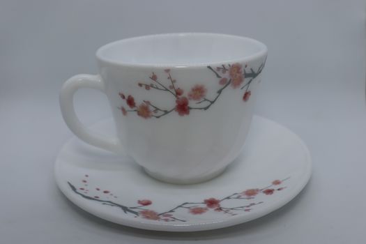 ceramic cup and plate closeup on white background