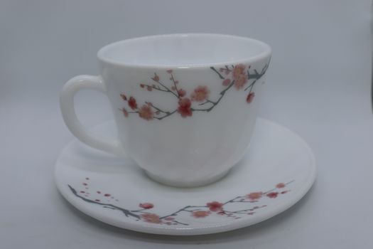 ceramic cup and plate closeup on white background
