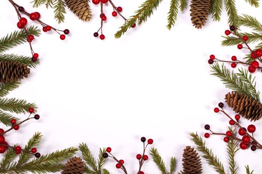 Christmas white blank card with copy space and frame decor of fir tree branch cones red holly berry isolated on white background