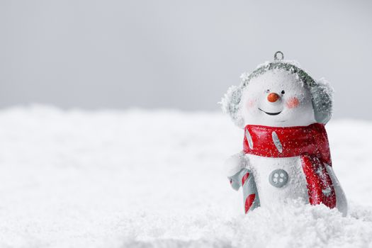 Christmas Snowman toy on winter background in the snow