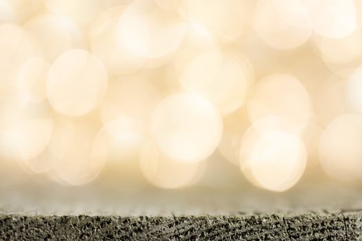 Golden bokeh background with wooden table close up
