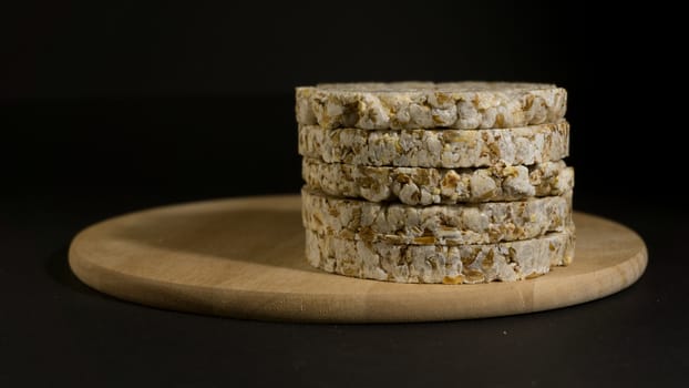 Grain crispbreads crispy rice and diet bread. Stack of puffed whole grain crispbread. Rice cake puffed rice on black background.