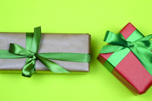 Gifts wrapped with colorful paper and green and black bows on green background