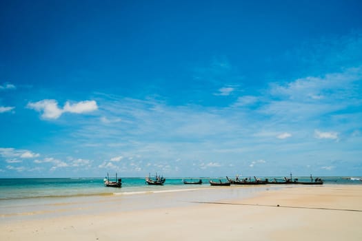 Tropical nature clean beach and white sand in summer season with sun light blue sky background.