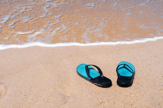 Slippers on the sand at the sea with space , summer holiday and vacation concept.