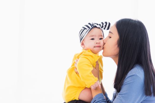 Portrait of beautiful young Asian mother kissing her infant newborn baby in a white bed, The mom loves his child, Healthcare and medical and mother day concept