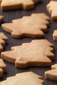 Top view of decorated green plain flavor gingerbread Christmas tree cookie on wooden table background with copy space, concept of holiday celebration.
