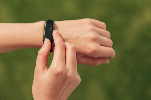A smartwatch on a woman's hand measures the heartbeat. Checking the pulse after fitness.