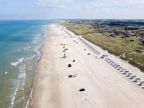 Lokken, Denmark - July 18, 2019: Aerial drone view of Lokken Beach with cars and beach huts.