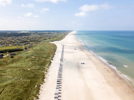 Lokken, Denmark - July 18, 2019: Aerial drone view of Lokken Beach with cars and beach huts.