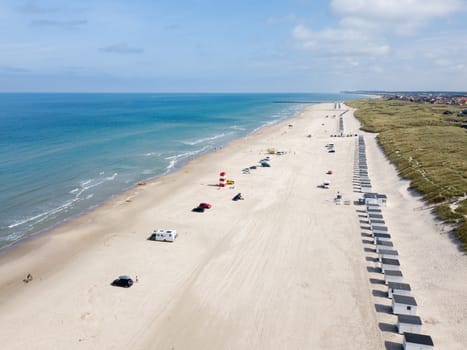 Lokken, Denmark - July 18, 2019: Aerial drone view of Lokken Beach with cars and beach huts.