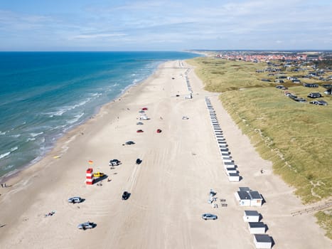 Lokken, Denmark - July 19, 2019: Aerial drone view of Lokken Beach with cars and beach huts.