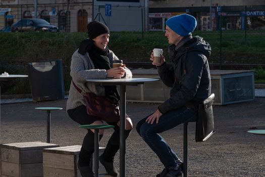 11/20/2020. Prague, Czech Republic. People during quarantine period due to coronavirus at Hradcanska metro stop in Prague. Friends are drinking coffee.
