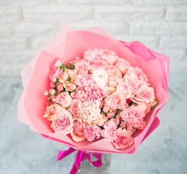 Close up view of nice subtle delicate pink bouquet with roses, dianthus, hypericum, clove. Shallow DOF. Copy space for text.