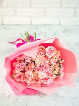 Close up view of nice subtle delicate pink bouquet with roses, dianthus, hypericum, clove. Shallow DOF. Copy space for text.