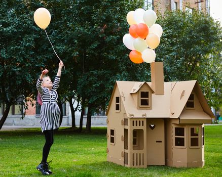 Child playing in a cardboard playhouse. Eco concept.