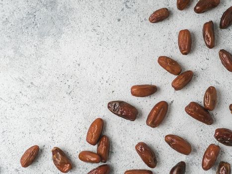 Sweet dried dates on gray cement background. Dried dates with copy space. Sugar free alternatives concept. One edge image with space for text. Top view or flat-lay.
