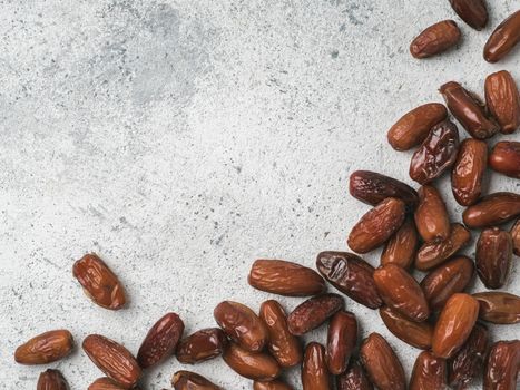 Sweet dried dates on gray cement background. Dried dates with copy space. Sugar free alternatives concept. One edge image with space for text. Top view or flat-lay.