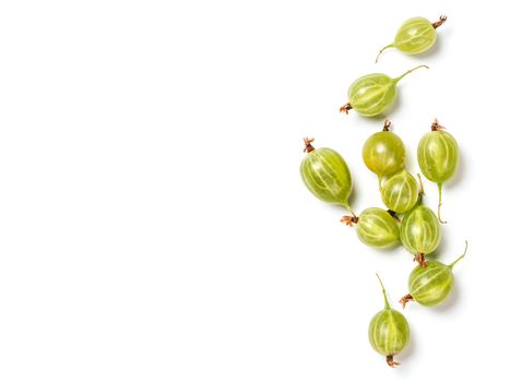 Heap of ripe green gooseberry berries on white background. Creative layout made of organic gooseberries. Isolated on white with clipping path. Top view or flat lay. Copy space for text. Food concept.