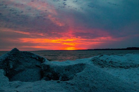 dramatic sunset at Port Stanley beach in the winter in Canada. High quality photo