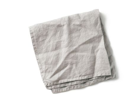 Folded gray linen napkin isolated on white background. Natural light gray linen napkin. Isolated on white with clipping path. Top view or flat lay.