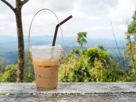 A glass of Thai tea on a mountain background in Khao Yai National Park