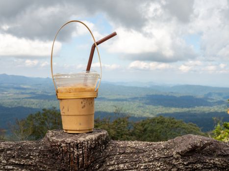 A glass of Thai tea on a mountain background in Khao Yai National Park