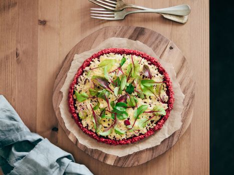 beetroot pizza crust with fresh swiss chard or mangold beetroot leaves.Ideas and recipes for healthy vegan snack.Egg-free pizza crust with chia seed and wholegrain brown rice flour.Copy space.Top view