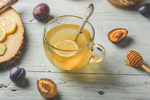 Cup of tea with lemon, honey and ginger over wooden surface