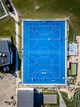 Valby, Denmark - March 22, 2020: Top down aerial drone view of a blue soccer field.