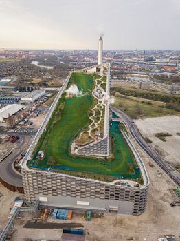 Copenhagen, Denmark - April 12, 2020: Aerial drone view of Amager Bakke, a waste to power plant with a ski slope on top.