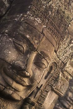 Stone face at the Bayon Temple the Tempel Ruins of Angkor Thom in the Temple City of Angkor near the City of Siem Reap in the west of Cambodia.  Cambodia, Siem Reap, February, 2001