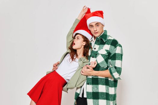 Cheerful drunk woman in the arms of a man Christmas holiday studio. High quality photo