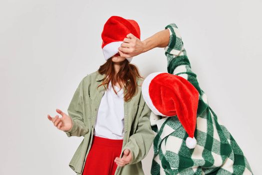 A man looks under the hat of a woman holiday fun New Year. High quality photo