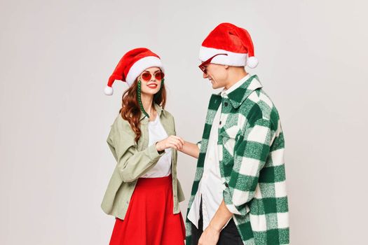 young couple in sunglasses in santa hat hug friendship holiday. High quality photo