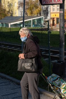 11-22-2020. Prague, Czech Republic. People during quarantine period due to coronavirus (COVID-19) at Hradcanska metro stop in Prague 6. Old woman walking.