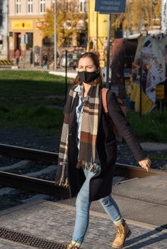 11-22-2020. Prague, Czech Republic. People during quarantine period due to coronavirus (COVID-19) at Hradcanska metro stop in Prague 6. Young woman walking.