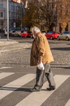 11-22-2020. Prague, Czech Republic. People during quarantine period due to coronavirus (COVID-19) at Hradcanska metro stop in Prague 6. Old man walking.