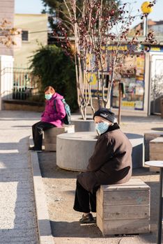 11-22-2020. Prague, Czech Republic. People during quarantine period due to coronavirus (COVID-19) at Hradcanska metro stop in Prague 6. Old women sitting.